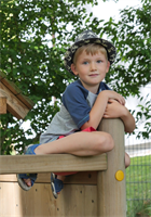 Kind sitzt auf dem Kletterhaus